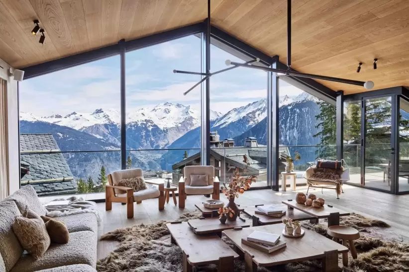 Interior de una casa de montaña con vista a los Alpes